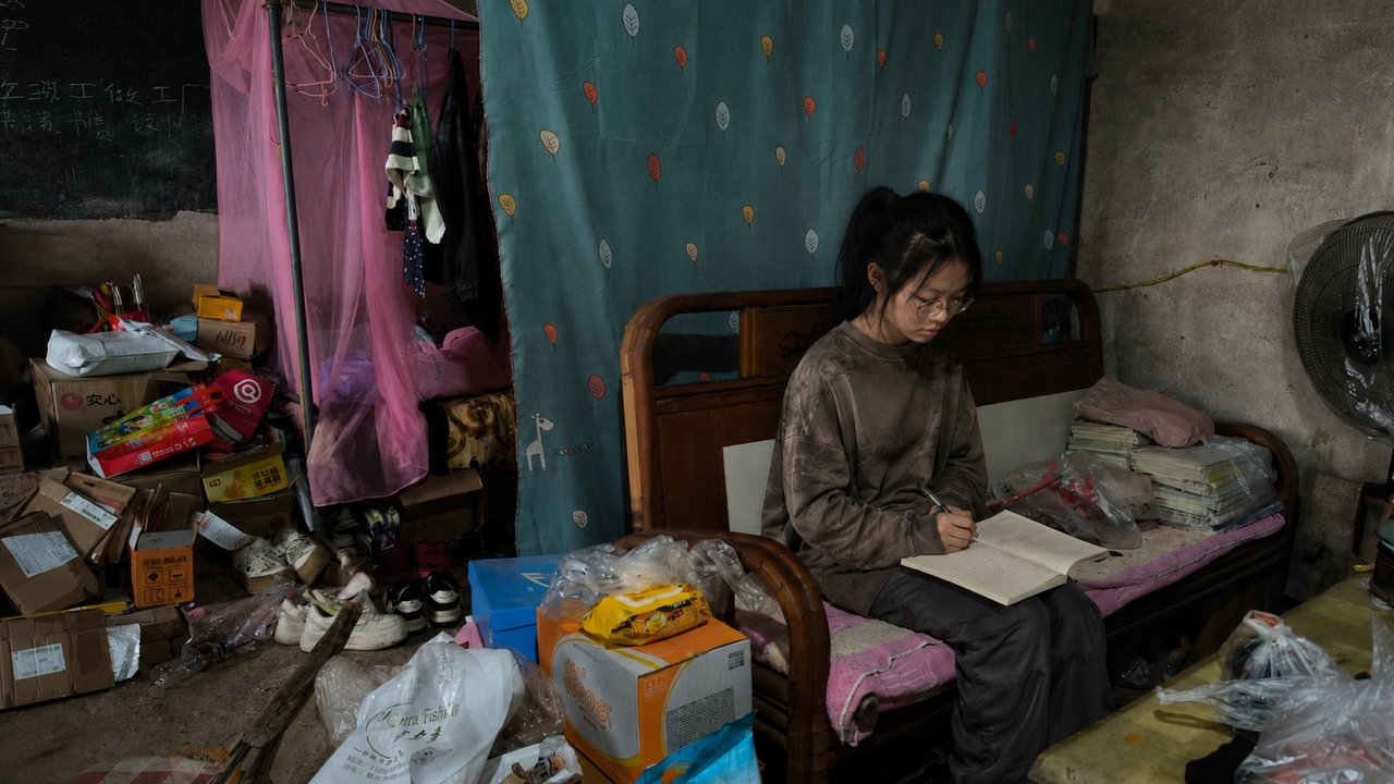 乡村女童在床边书写功课 — A rural girl writing at her bedside